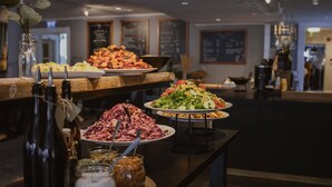 A buffet with various dishes, including salads, fruits, and meats. - Home Hotel Uman (Umea)
