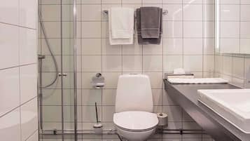 A modern bathroom with a glass shower enclosure, a toilet, a sink, and two towels.