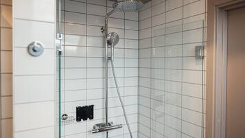 Una ducha moderna con cabina de vidrio, grifería de cromo y pared de azulejos.