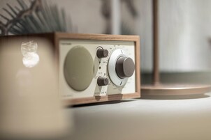 Una radio antigua con estructura de madera, un altavoz grande y mandos de sintonía.