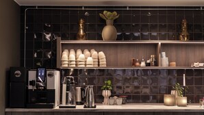 A modern kitchen with a coffee machine, a kettle, and various kitchenware on the counter.