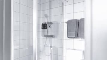Ein modernes Badezimmer mit weißen Fliesen, einer Duschkabine aus Glas und einem Handtuchhalter mit zwei Handtüchern.