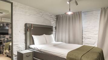 Une chambre moderne avec un lit, des tables de chevet, une armoire et une grande fenêtre avec des rideaux.