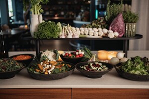 Une table de buffet proposant diverses salades et légumes.