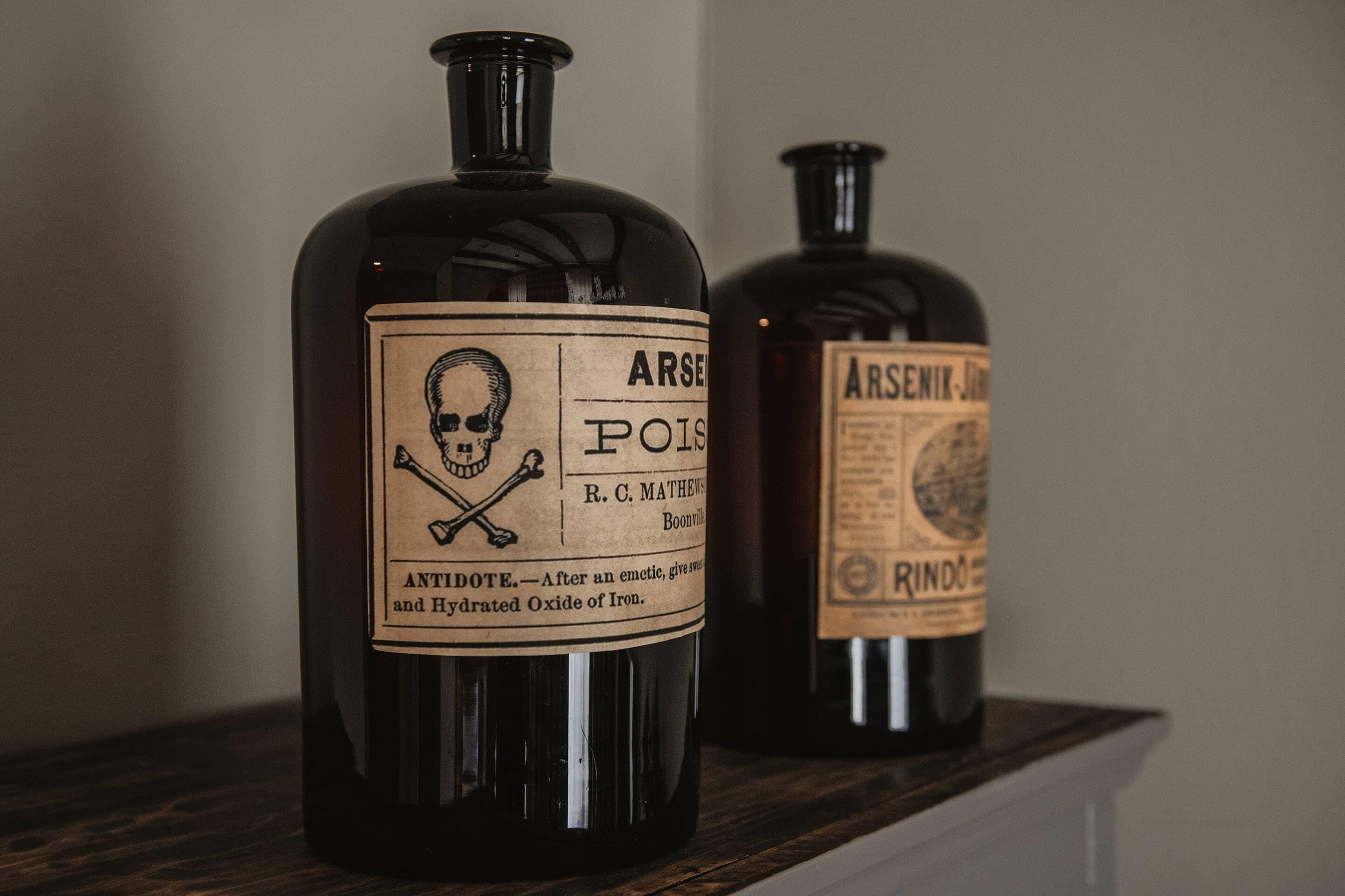 Two bottles of arsenic on a shelf.