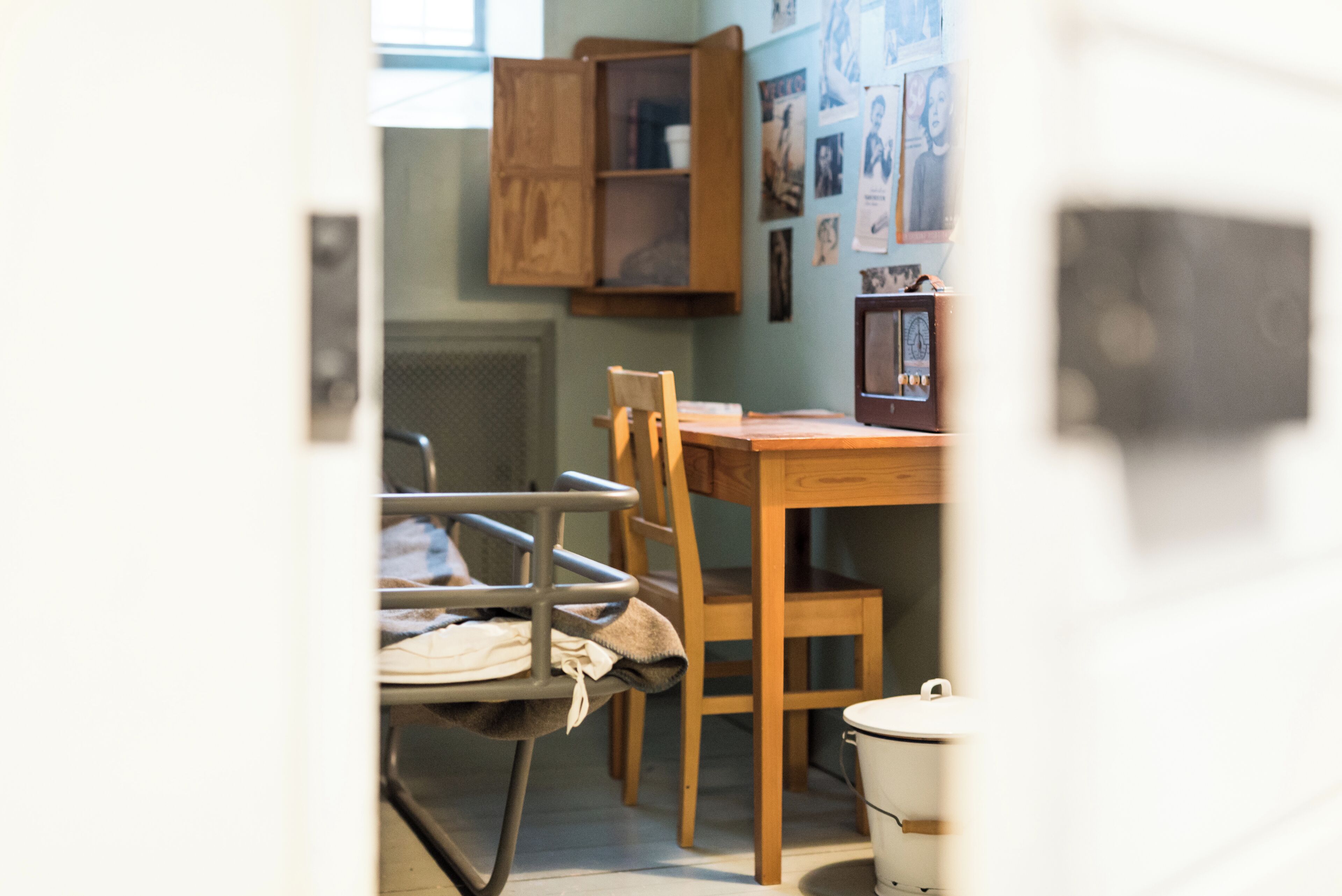 A room with a wooden dining table, a chair, a cabinet, and a radiator.