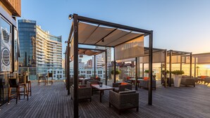 A rooftop terrace with outdoor seating, a pergola, and a cityscape view. - Enjoy Punta del Este (Punta del Este)