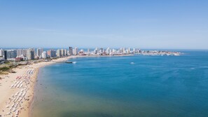 Perto da praia, guarda-sóis, toalhas de praia, bar na praia