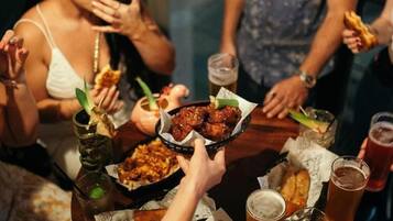 A group of people around a table with food and drinks.