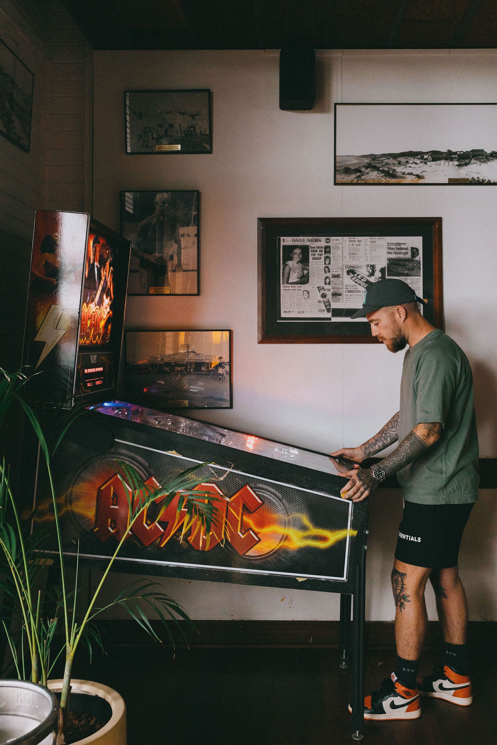 Un hombre está de pie frente a un piano con un cartel de AC/DC.
