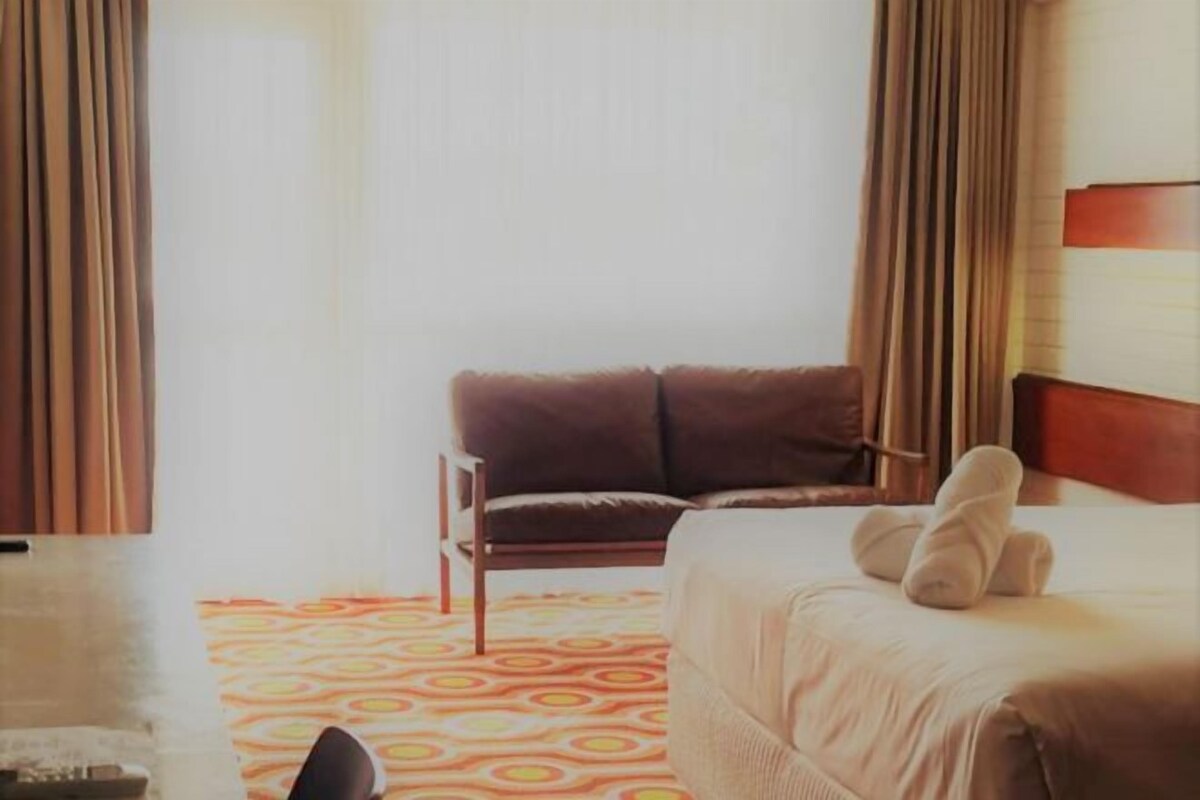 Een hotelkamer met een bed, een stoel en een kamer met een patroon.