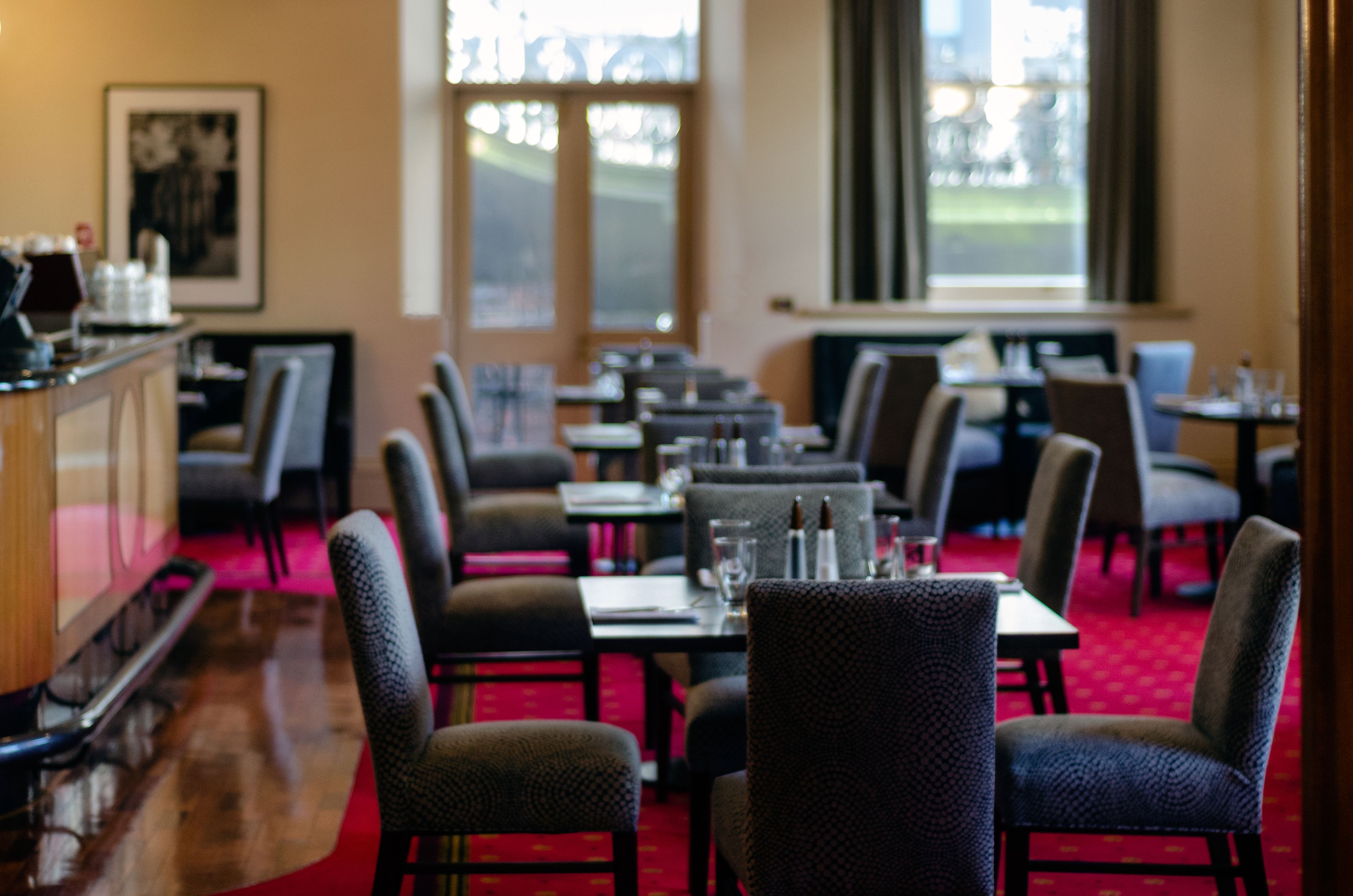 Ein Restaurant mit einer langen Theke, mehreren Tischen und Stühlen.