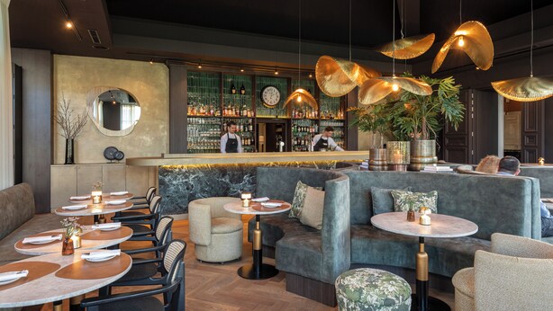 A modern bar area with round tables, sofas, and hanging lamps. -  Dukes’ Palace Residence – by Dukes’ Hotel Collection (Bruges)