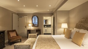 A hotel room with a large bed, two armchairs, a desk, and a bathroom visible through an open door. -  Dukes’ Palace Residence – by Dukes’ Hotel Collection (Bruges)