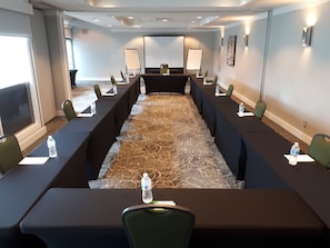 A conference room with a long table, chairs, and a carpeted floor. - Holiday Inn Vancouver Airport- Richmond by IHG (Richmond)