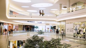A multi-level shopping mall with glass railings, a central atrium, and potted plants. - Holiday Inn Vancouver Airport- Richmond by IHG (Richmond)