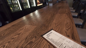 A wooden bar counter with a menu on it. - Holiday Inn Vancouver Airport- Richmond by IHG (Richmond)