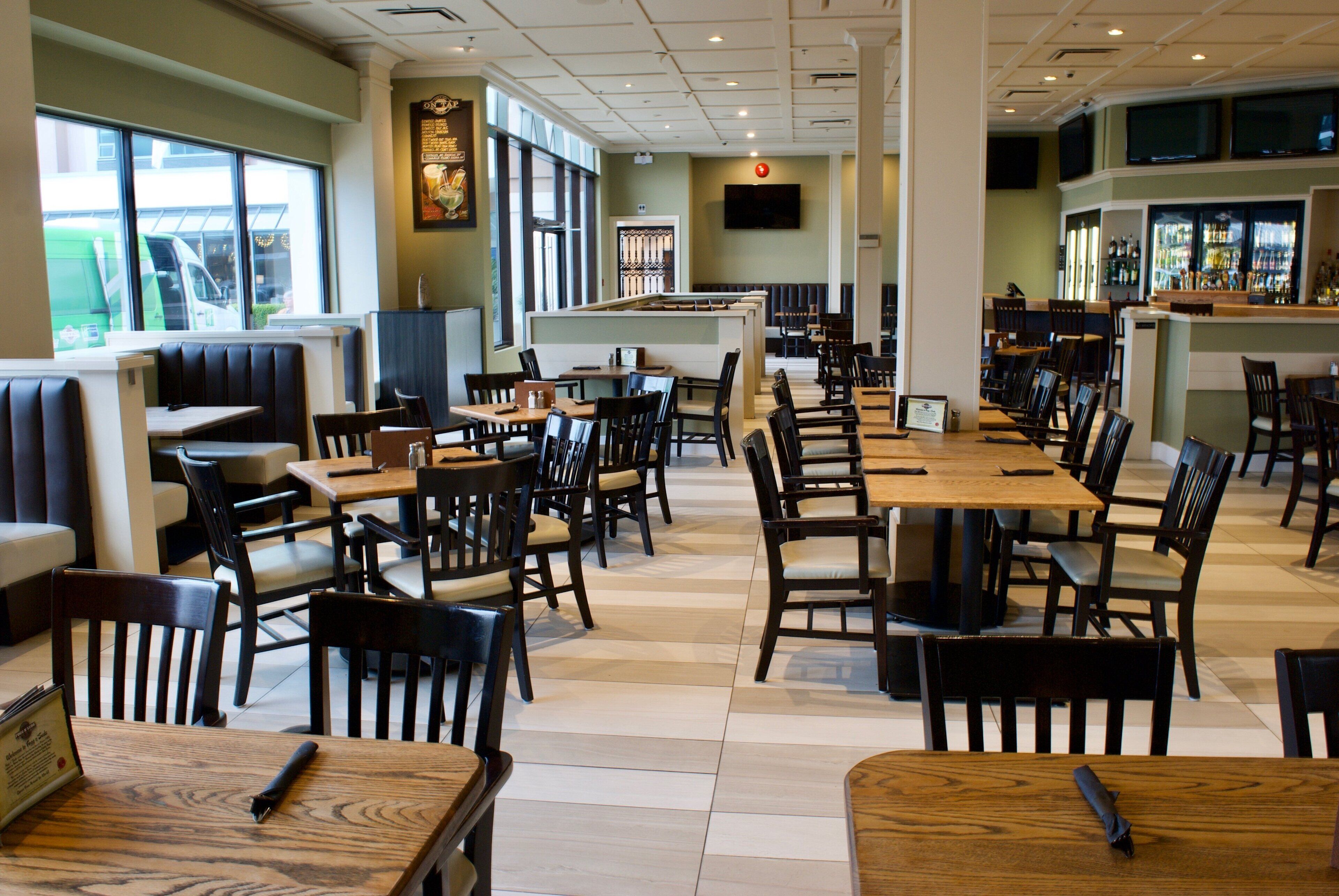 A restaurant interior with booths, tables, and a bar area.
