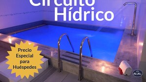 A swimming pool with a blue interior, metal handrails, and a towel on the edge. - 101 Park House (Bogotá)