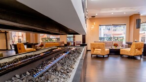 A modern lobby with a long water feature, comfortable seating, and large windows. - 101 Park House (Bogotá)
