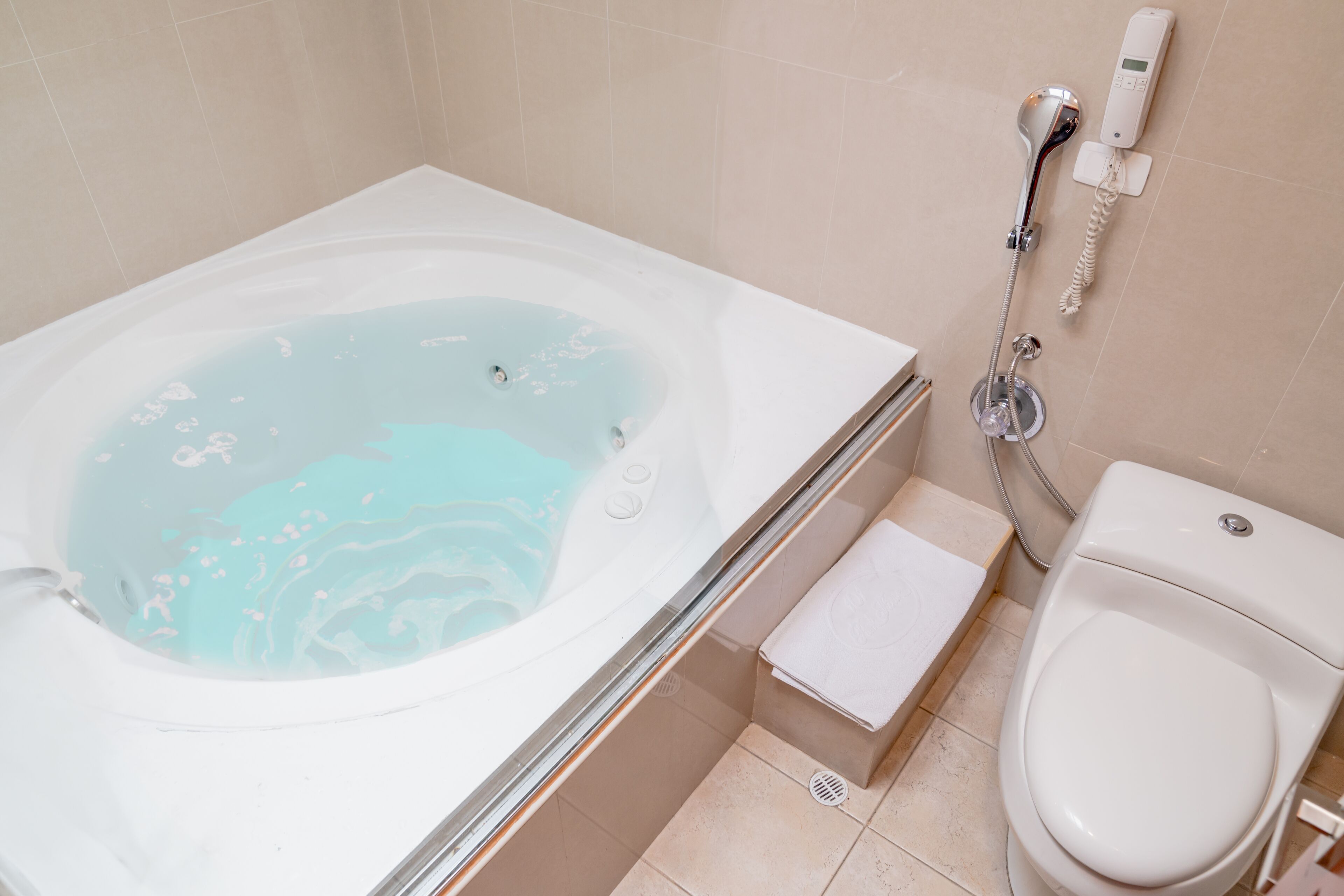 Een badkamer met een bad, toilet en douche.