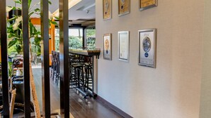 A hallway with a reception desk, framed awards on the wall, and a view into the dining area. - 101 Park House (Bogotá)