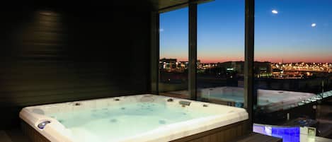 Un jacuzzi en una habitación moderna con vistas a la ciudad.