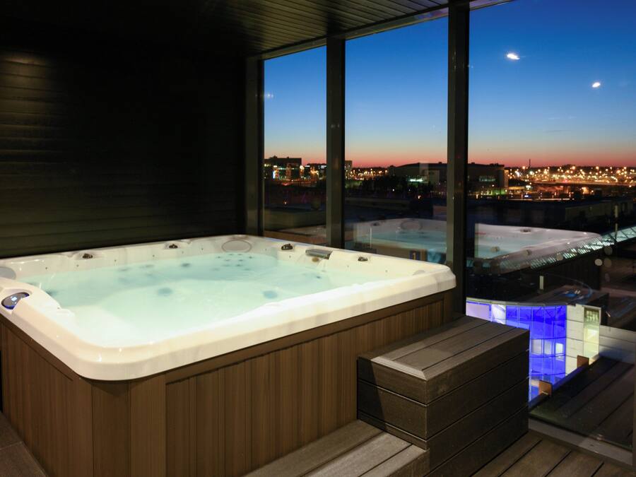 Un bain à remous dans une chambre moderne avec vue sur la ville.