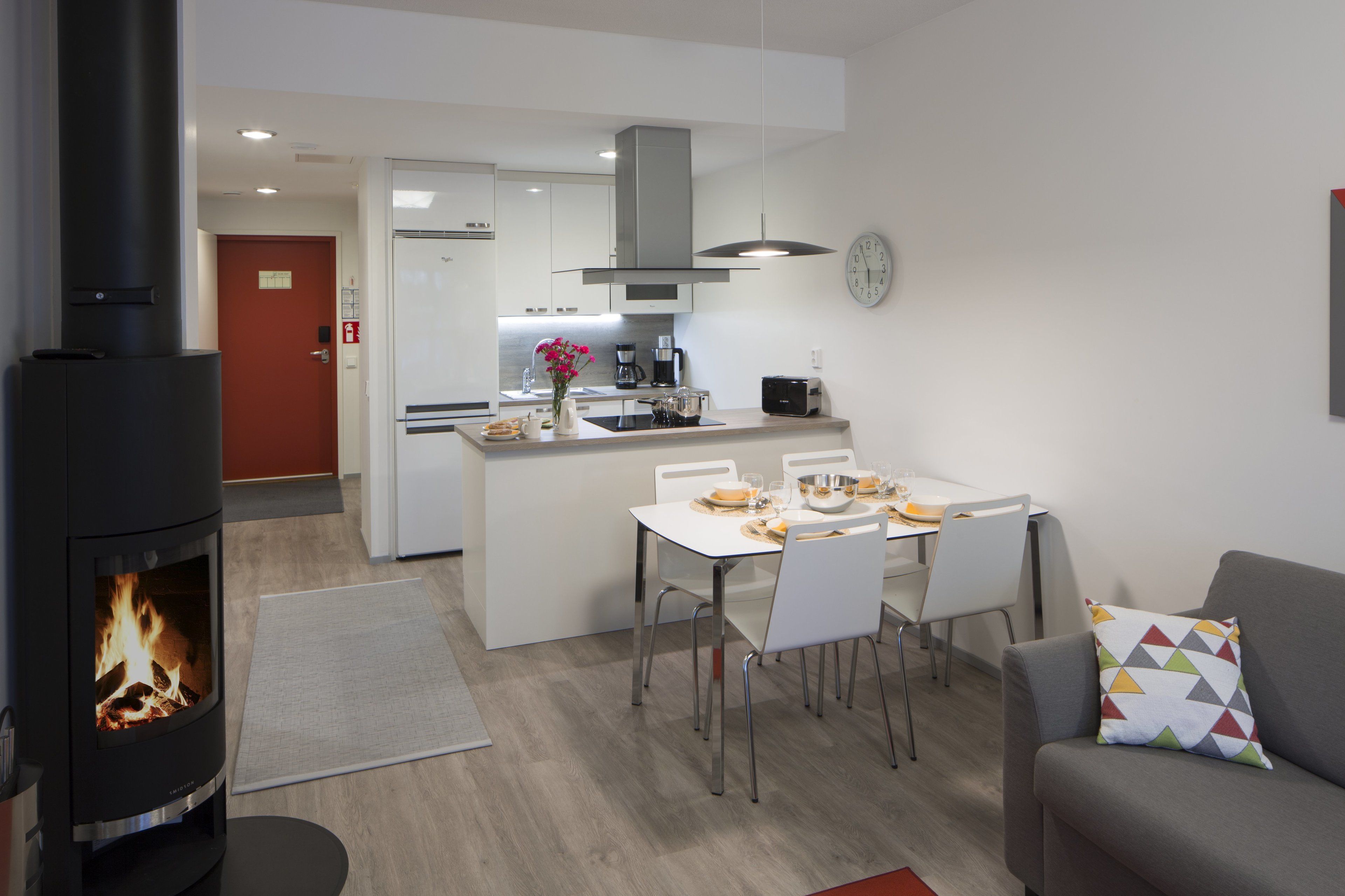 Una cocina moderna con armarios blancos, una isla central y una estufa empotrada.