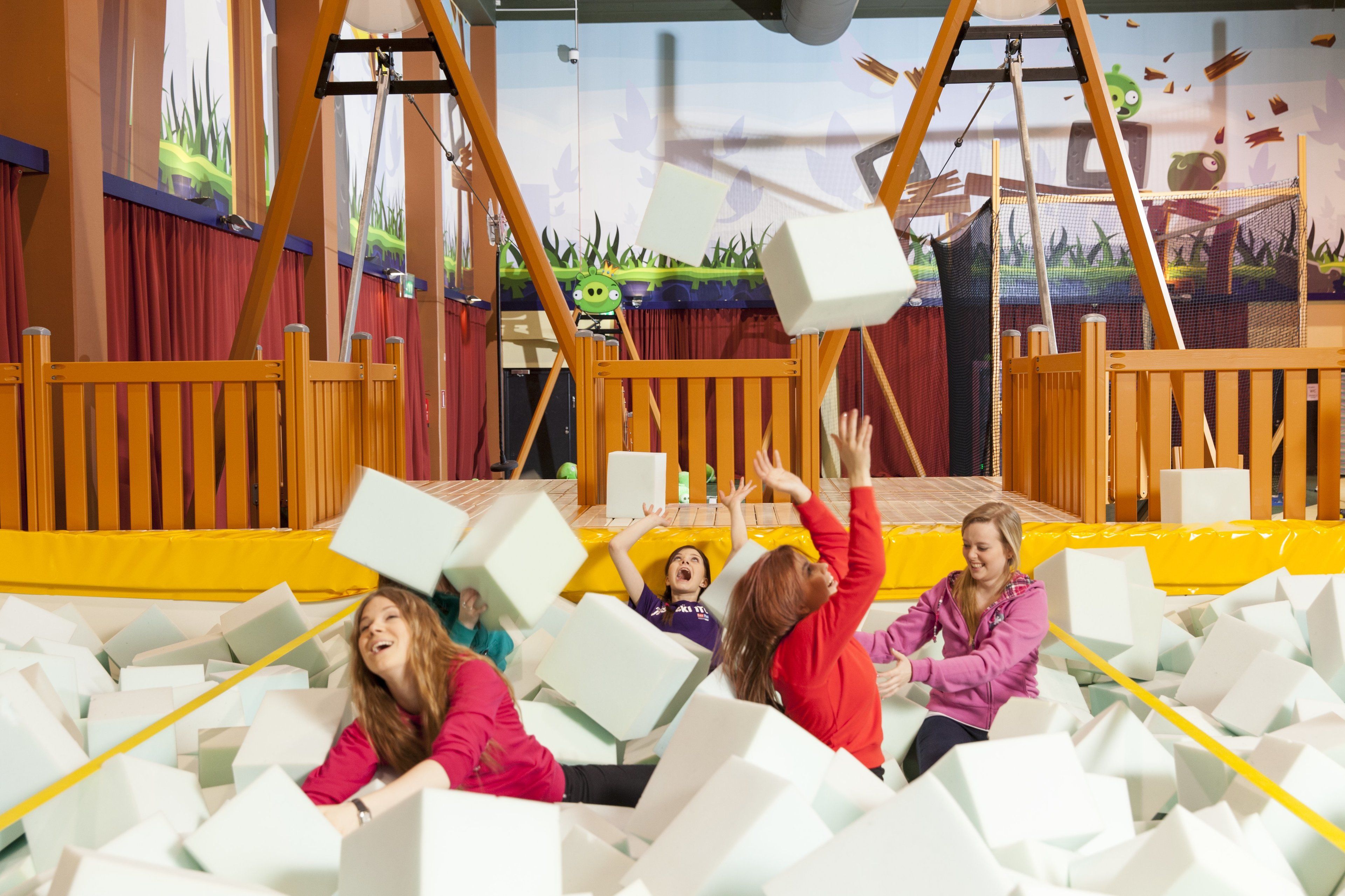 A play area with a trampoline and foam blocks.
