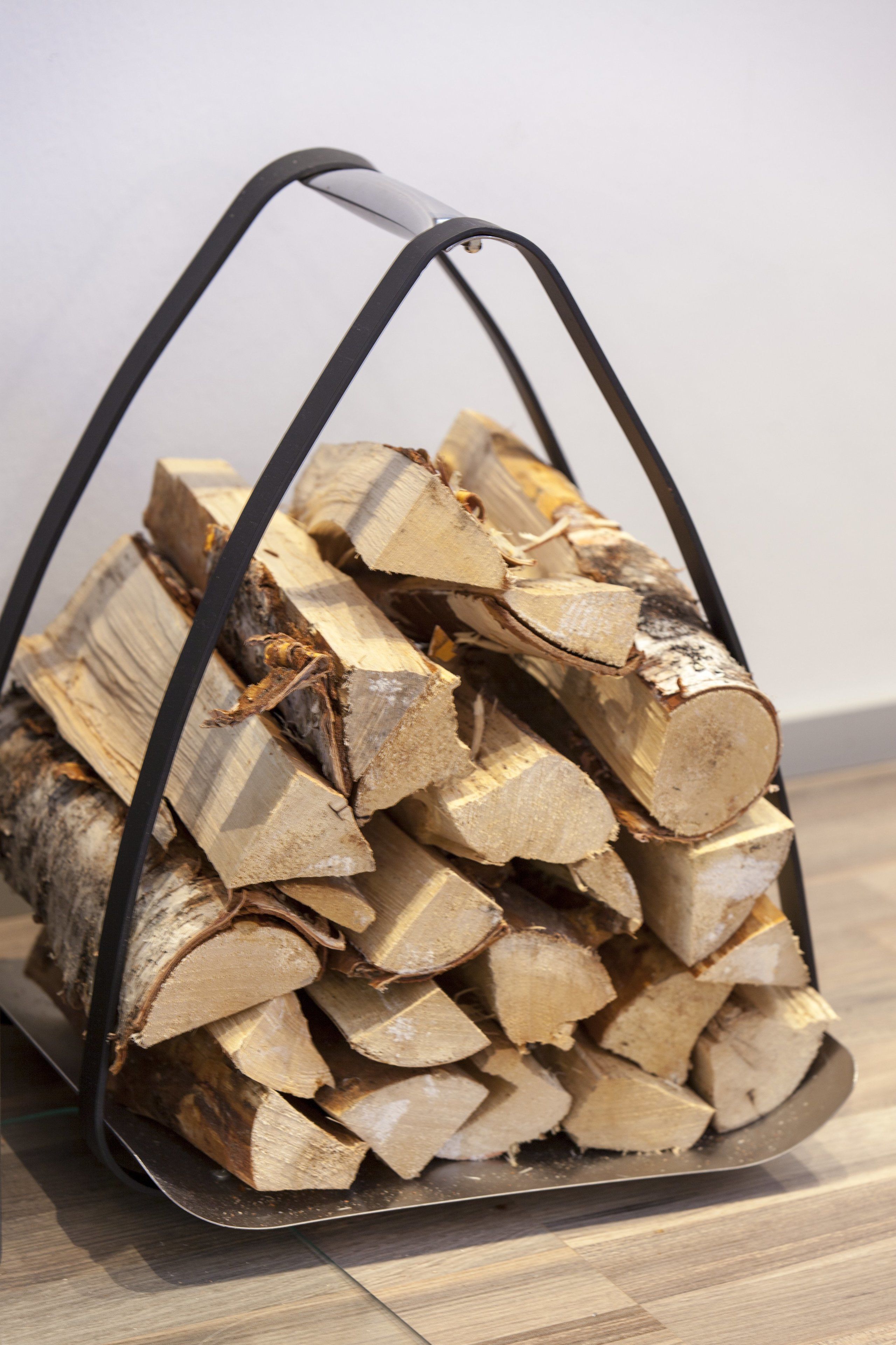 A metal basket filled with neatly stacked firewood.