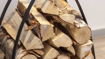 A metal basket filled with neatly stacked firewood.