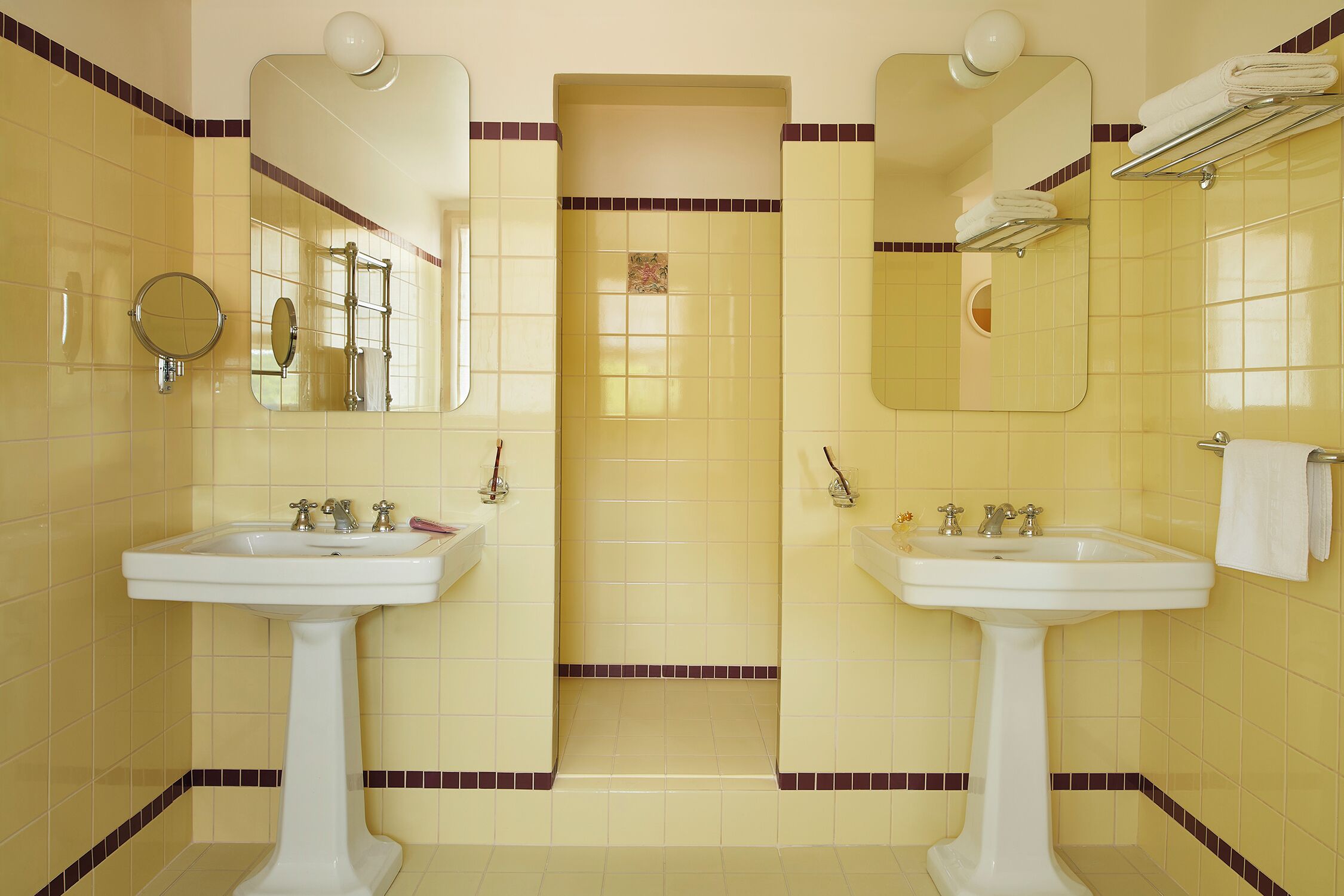 Ein Badezimmer mit zwei Waschbecken, einem Spiegel und einem Handtuchhalter.
