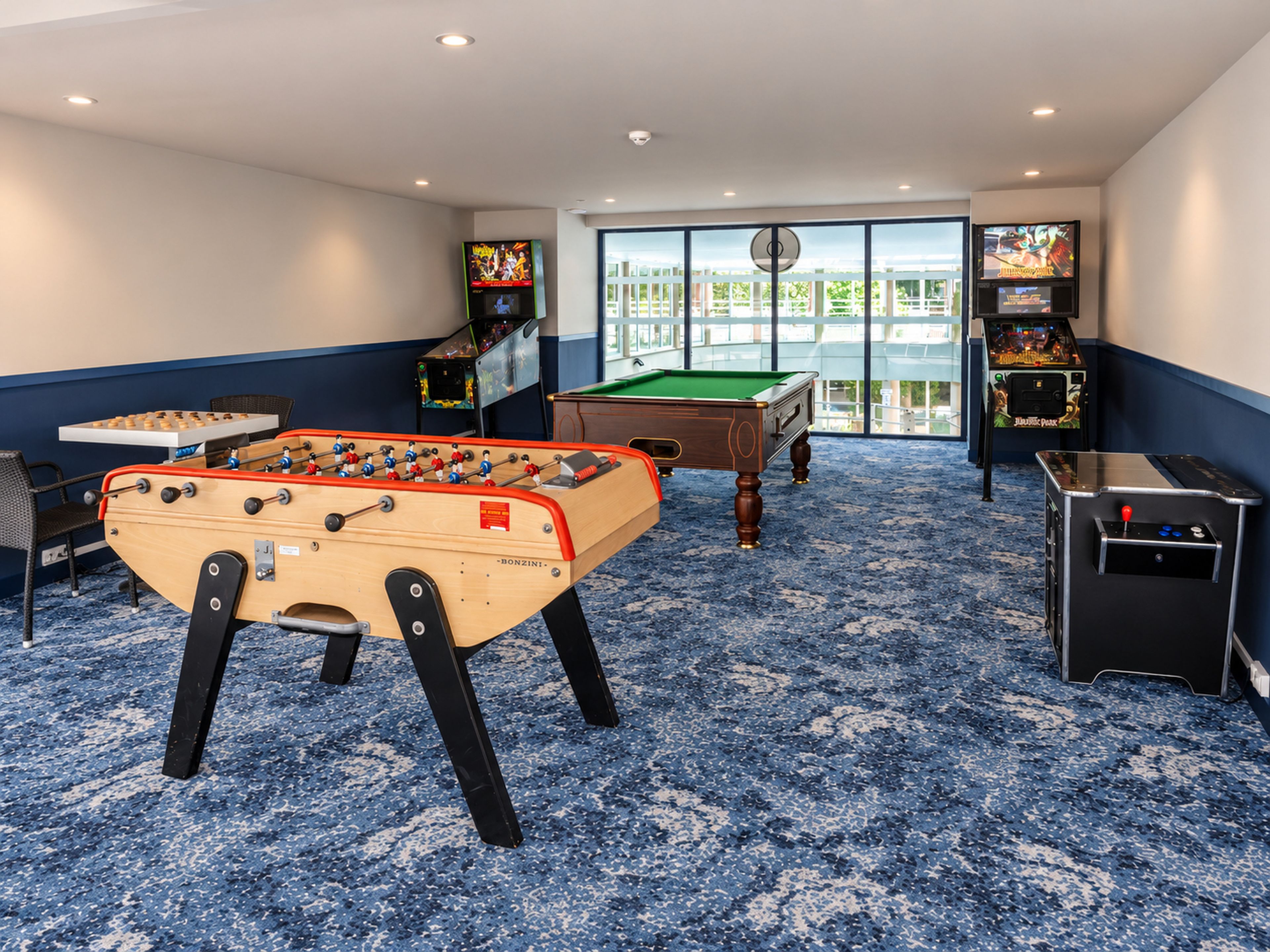Una sala de recreación con mesa de futbolín, mesa de billar y juegos de arcade.