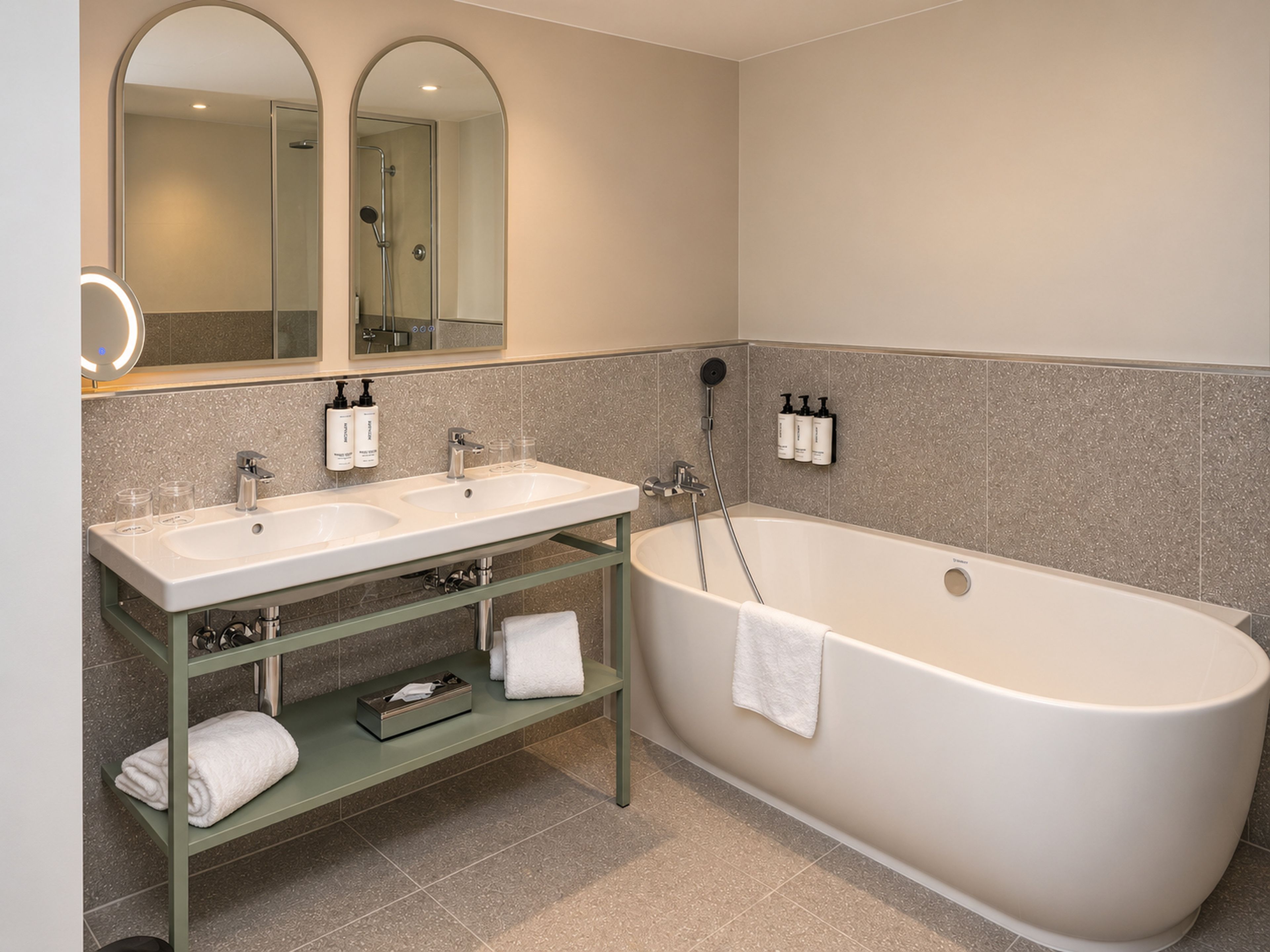 Une salle de bain avec deux lavabos, une baignoire et un miroir.
