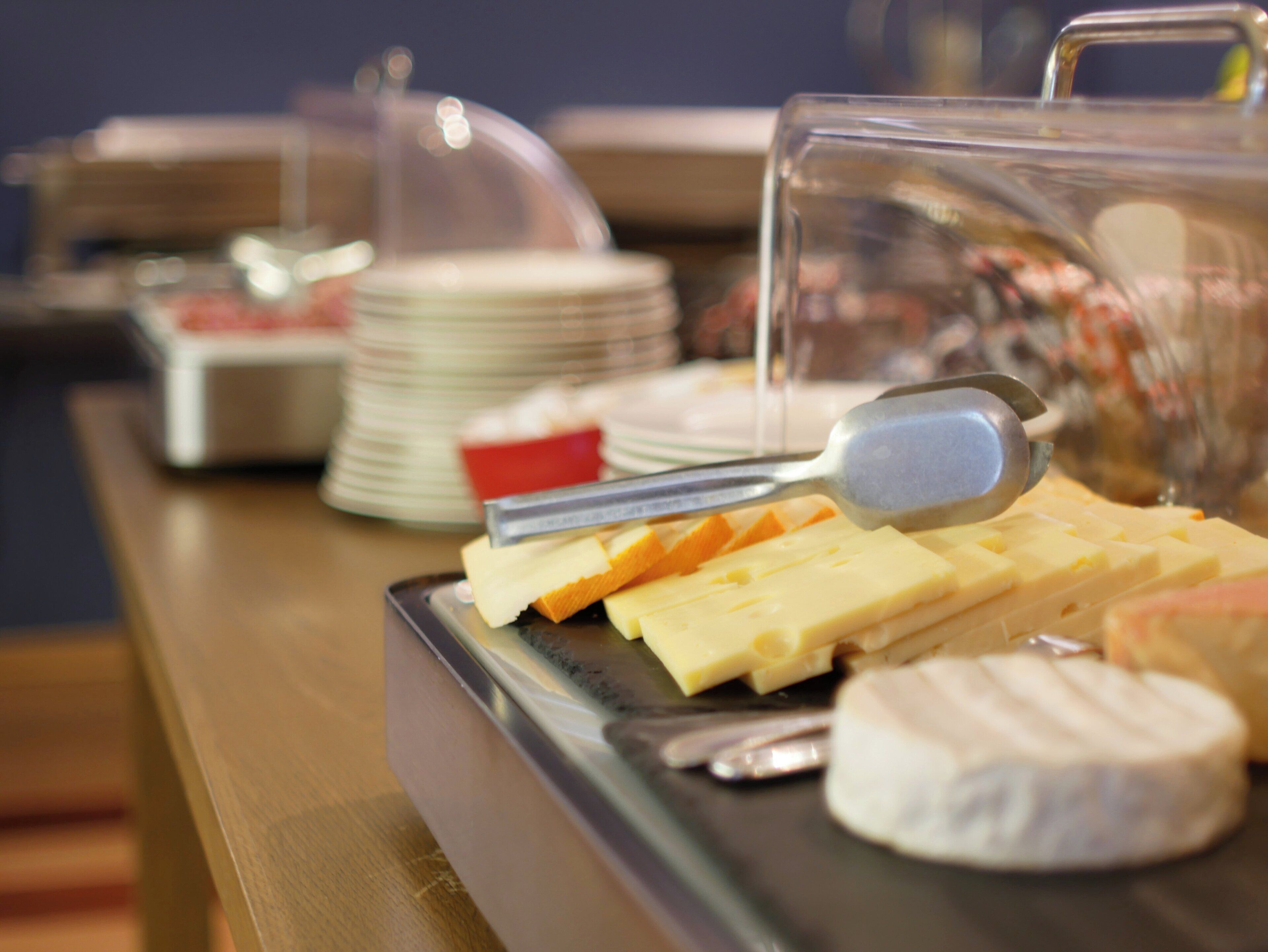 Ein Buffet mit verschiedenen Käsesorten und einem Käsehobel.