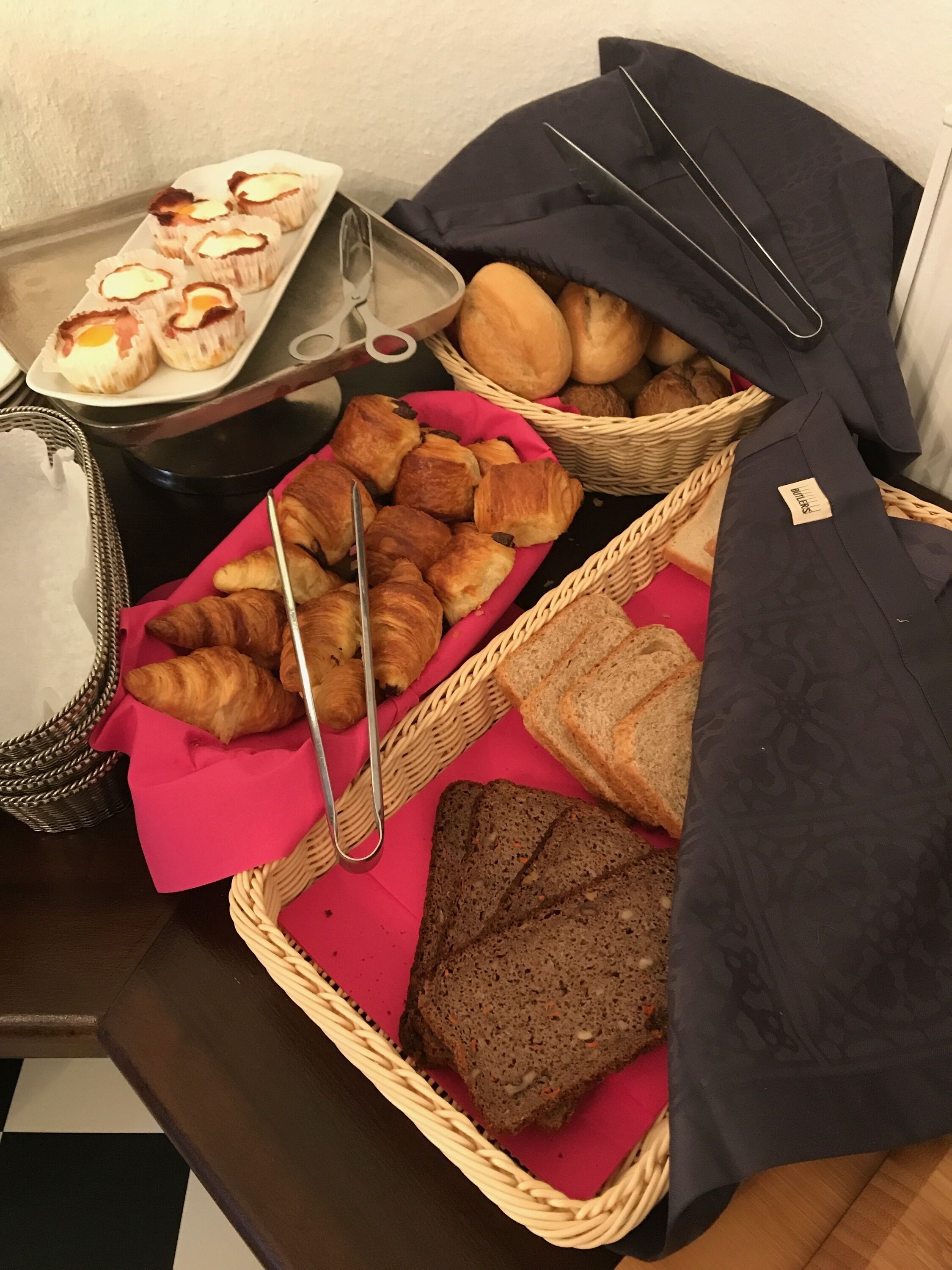 A table with various baked goods including croissants, bread, and pastries.