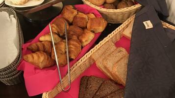 A table with various baked goods including croissants, bread, and pastries.