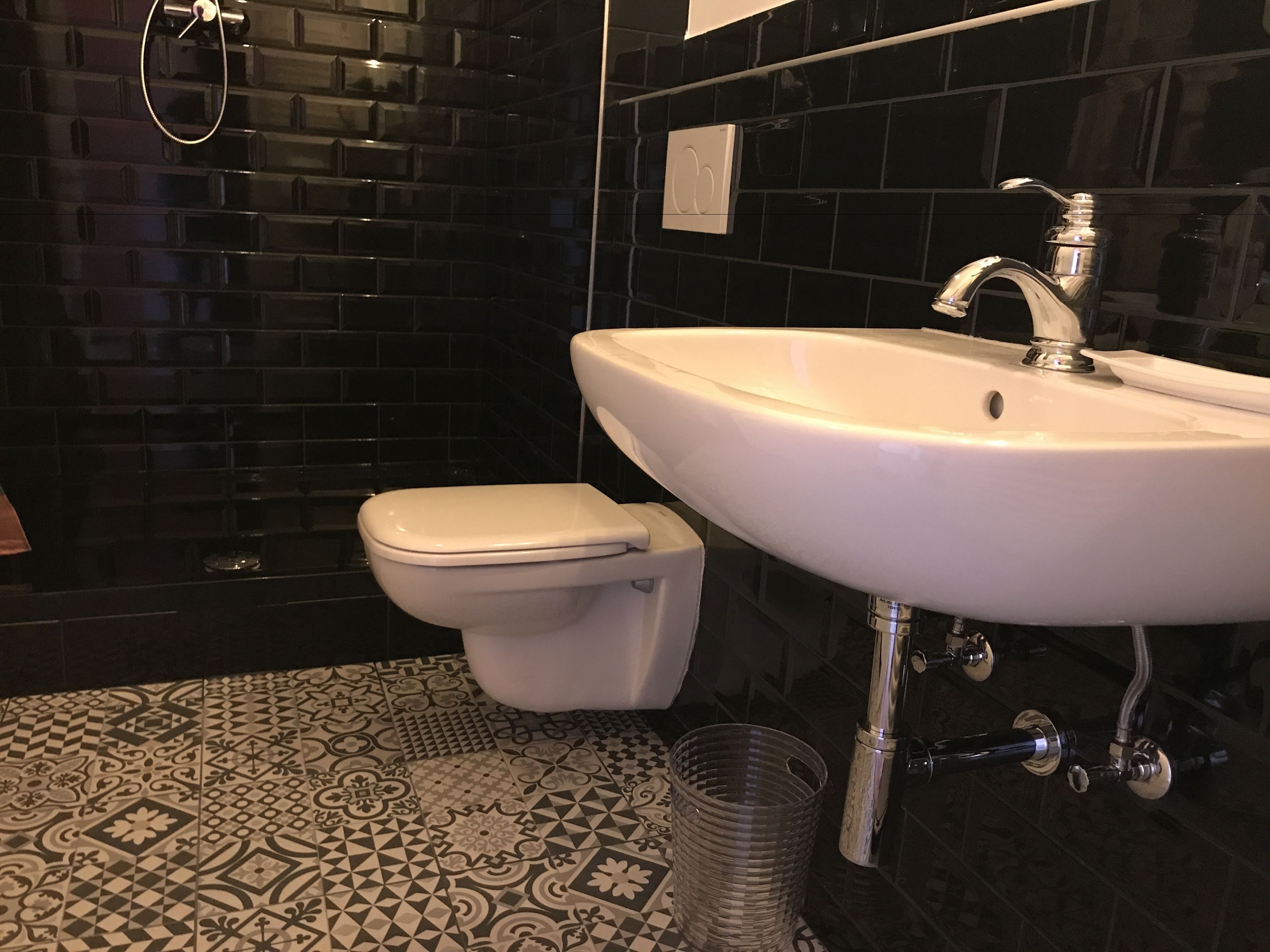 A bathroom with a toilet, sink, and shower.