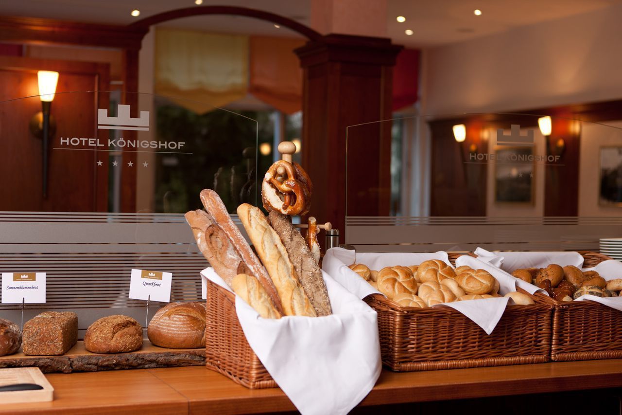 Mostrador de panadería con diversos panes y pasteles en un entorno hotelero.