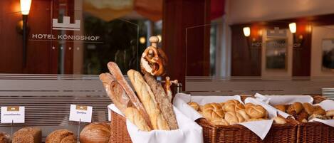A bakery display with various breads and pastries in a hotel setting.