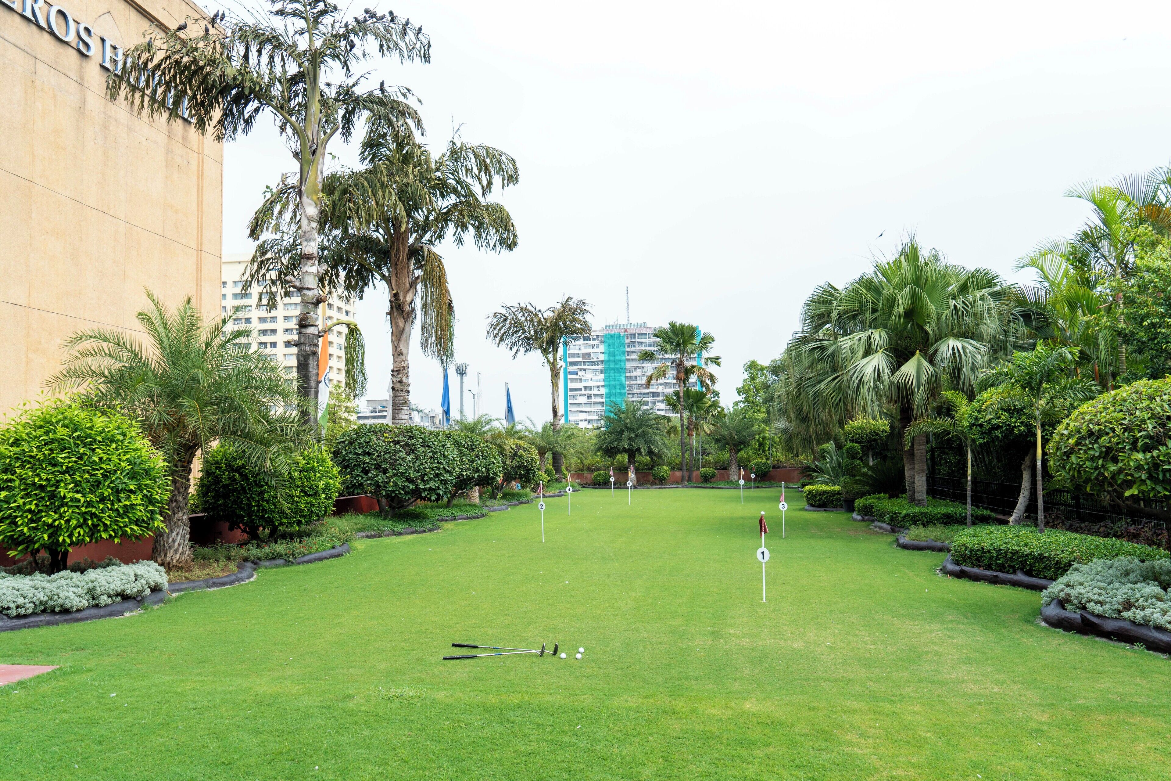 Ein gepflegter Golfplatz mit freier Bahn, umgeben von üppiger Vegetation und Palmen.