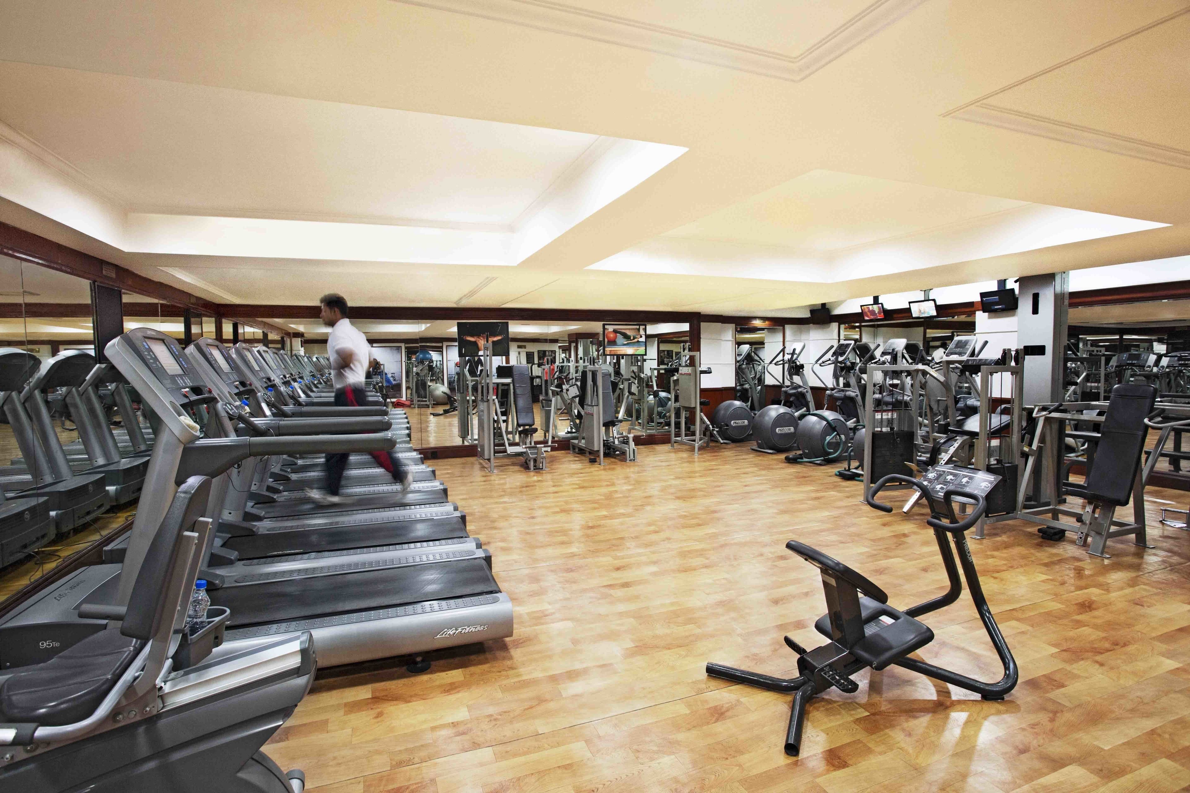 A gym with treadmills, elliptical machines, and weight machines.