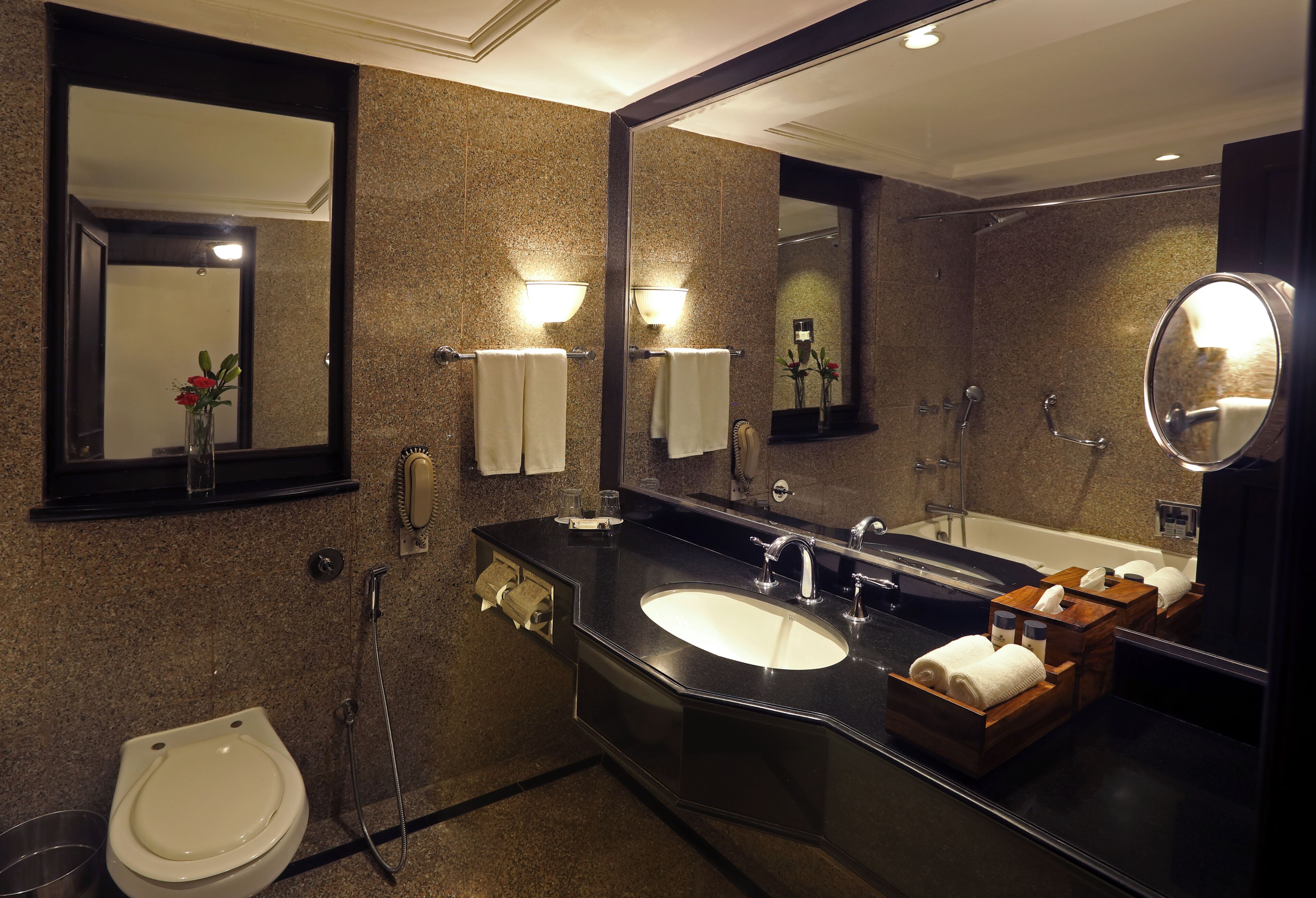 A modern bathroom with a large mirror, a sink, a toilet, and a shower.
