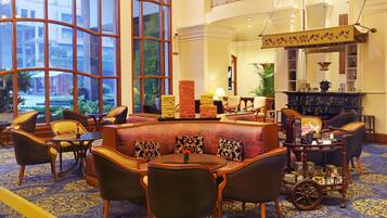 A hotel lobby with a large window, seating area, and a fireplace.