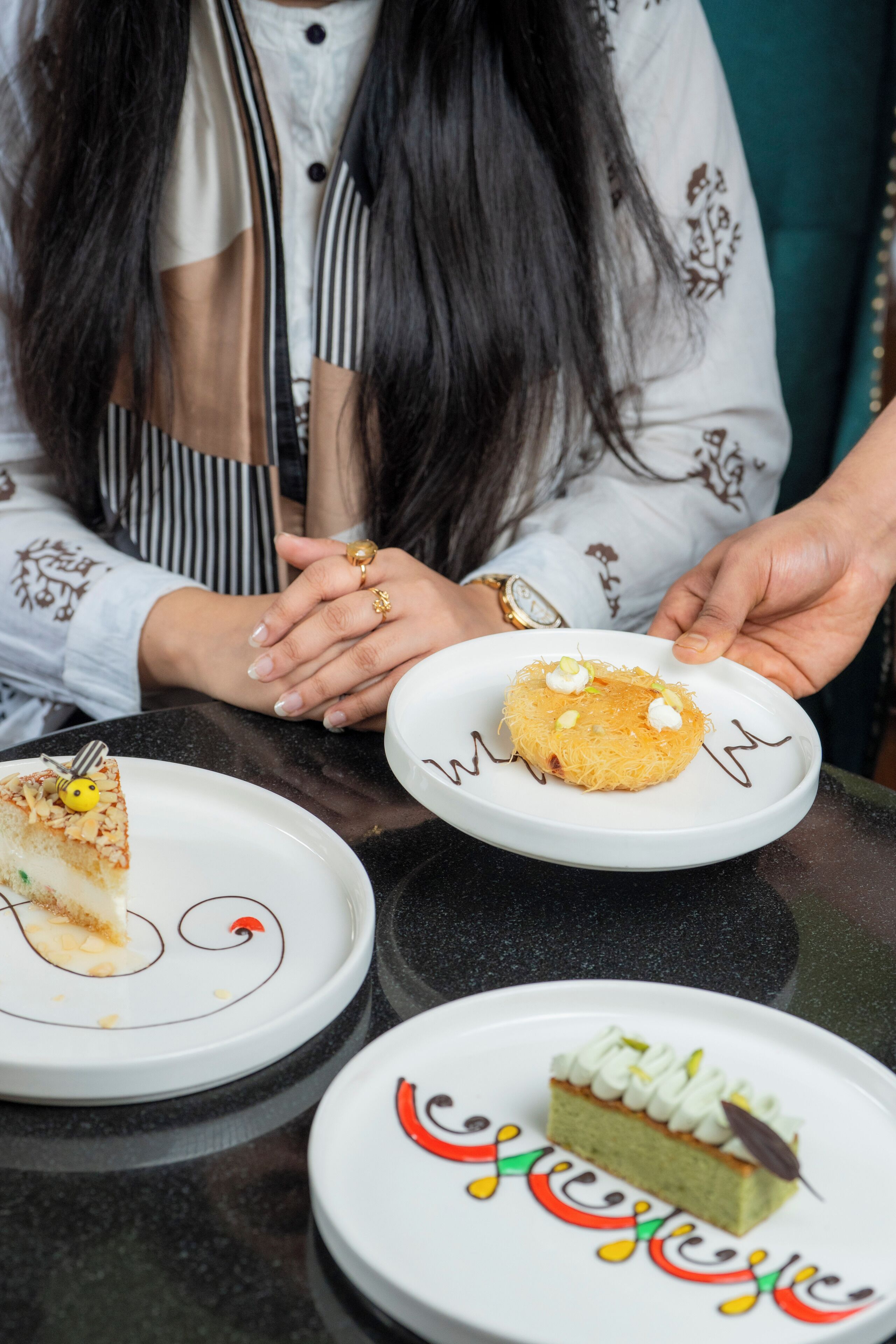 A table with two plates of food, one with a slice of cake and the other with a dessert.