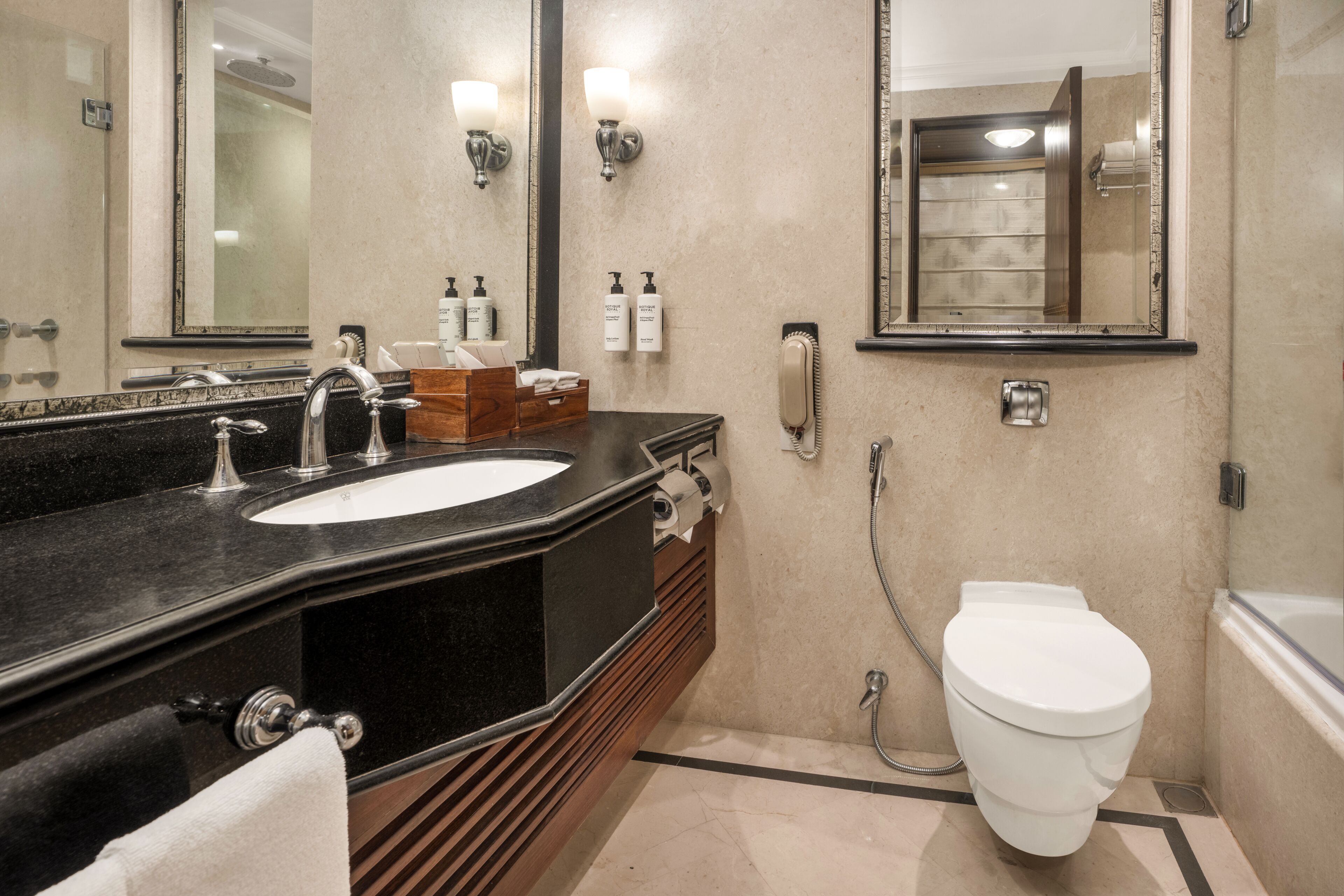 Un baño con lavamanos, espejo, inodoro y ducha.