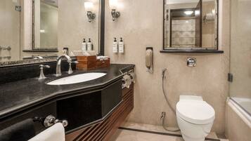 A bathroom with a sink, mirror, toilet, and shower.