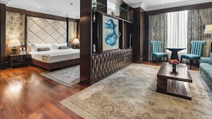 A hotel room with a bed, a sofa, a coffee table, and a TV.
