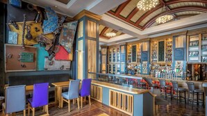 A bar area with wooden furniture, a counter, and a variety of bottles and glasses. - Talbot Hotel Wexford (Wexford)